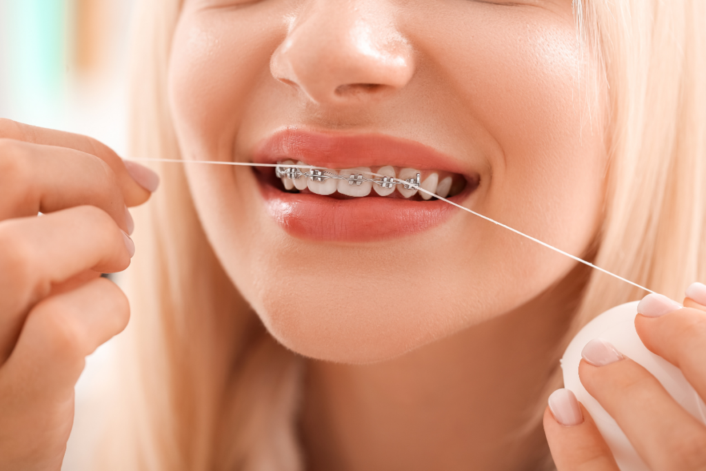 Girl with braces flossing her teeth