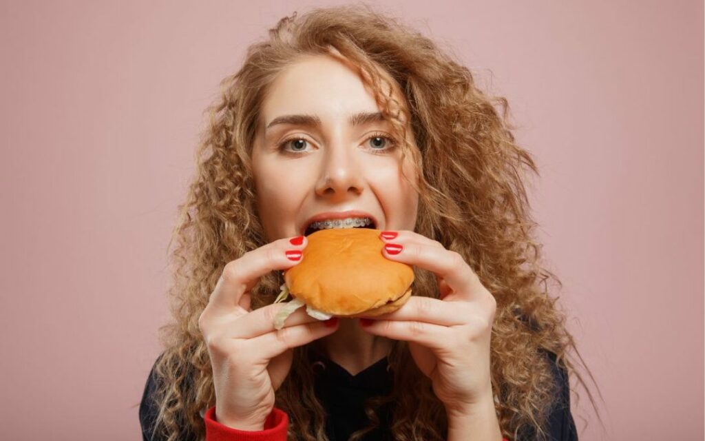 Woman with braces eating a sandwhich